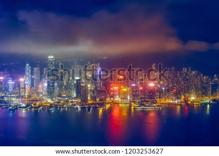 Aerial view of illuminated Hong Kong skyline cityscape downtown skyscrapers over Victoria Harbour in the evening. Hong Kong, China