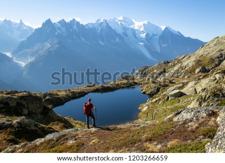 Hiker looking at Lac de Cheserys on the famour Tour du Mont Blanc near Chamonix, France. Royalty-Free Stock Photo #1203266659