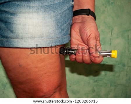 An allergic woman injecting an adrenaline injection into her thigh Royalty-Free Stock Photo #1203286915