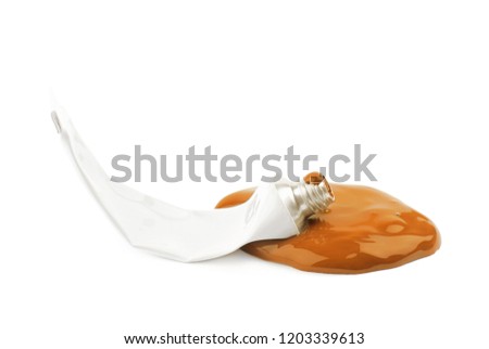 Used paint tube lying in a dye spill splash, composition isolated over the white background