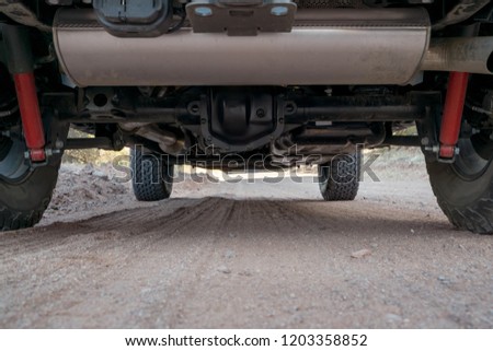 View of the undercarriage (underside) of an off road 4x4 vehicle out on a dirt trail in the desert  Royalty-Free Stock Photo #1203358852