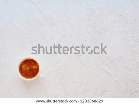 White cup of coffee on the textured table