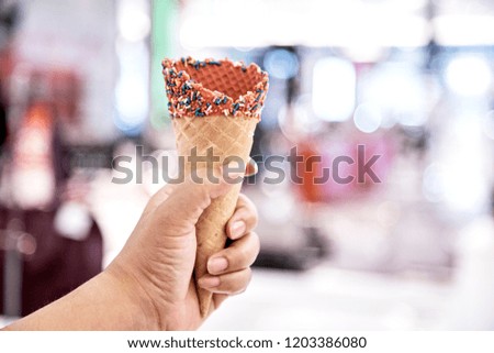 Hand holding empty wafer cone for ice cream indoor Shopping Mall. Close up, High resolution product