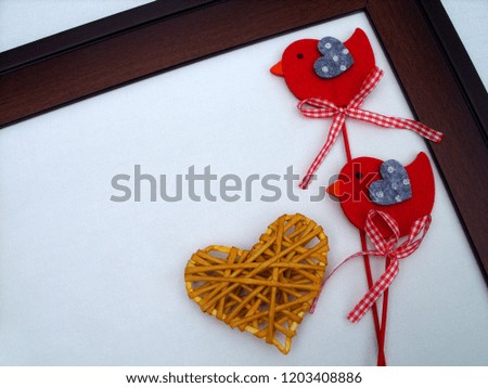 red birds with a yellow heart in a wooden frame