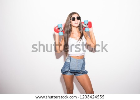 Happy young woman in sunglasses with skateboard over white background