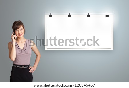 beautiful young woman standing next to a modern copy space and making phone call