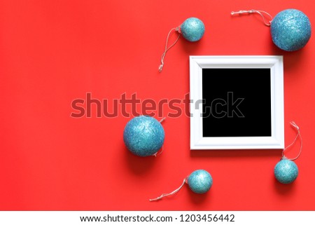 Empty black photo frame and christmas decoration on red background for design in your work concept.