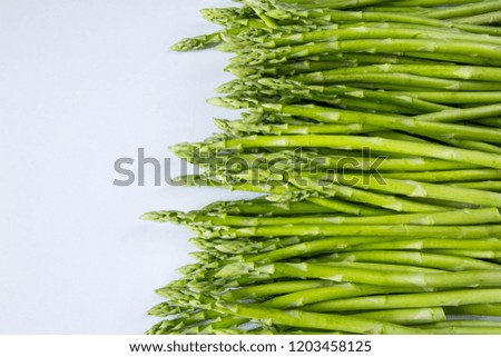 Copy space picture. Green raw asparagus sticks at the right side. Empty space for pasting text or writing title. White background, high resolution