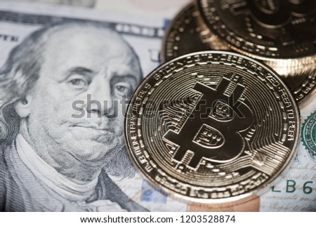 Bitcoins (Cryptocurrency) and dollars bills (United States $100 bill)