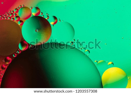 Abstract background with colorful gradient colors. Oil drops in water abstract psychedelic pattern image. Green, black, red and yellow colored abstract pattern.
