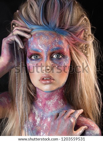 close up  portrait of young beautiful girl with colorful face painting. Halloween professional makeup. hair in paint. beauty portrait. blonde long hair