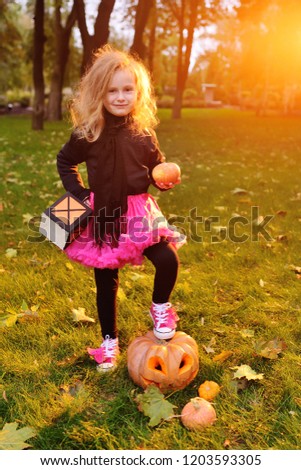 baby little girl in carnival costume with pumpkin celebrating halloween