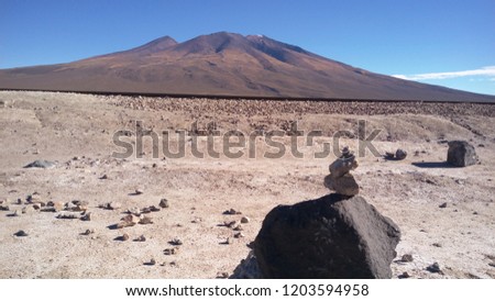 A cairn of stones with a mountain in the background