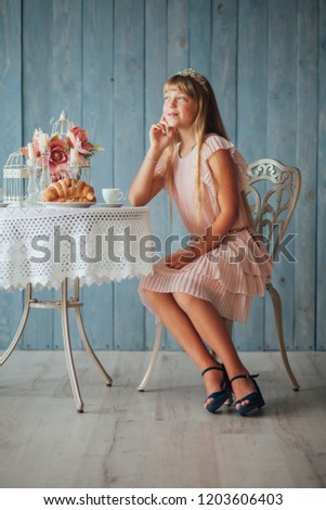 girl drinks tea and breakfast croissant