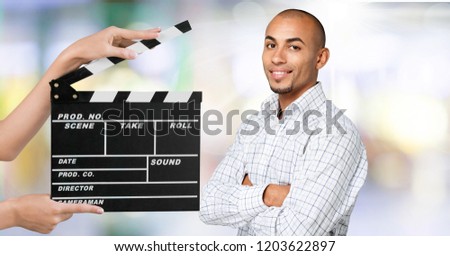 Young woman with cinema clapper smiling at camera