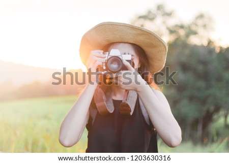 Asian woman photographer traveler with film camera and hat in forest. Travel with film camera concept.