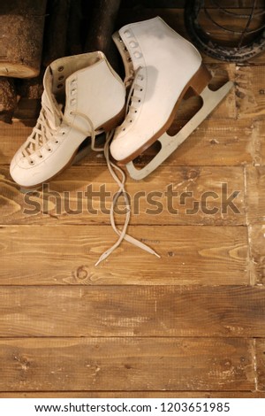 old vintage white skates on the wooden floor in the winter time. Hello December.