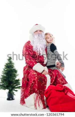Santa Claus gives gifts to the pretty little girl