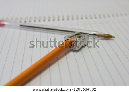 Pencil and sharpener on a notebook.