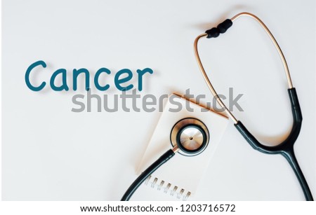 Conceptual image with Cancer  inscription with the view of stethoscope and notebook on the white background. Medical Conceptual. Copy space.
