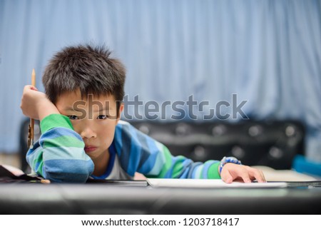  chinese children writing paper with pencil, boy doing homework, boy writing on paper
