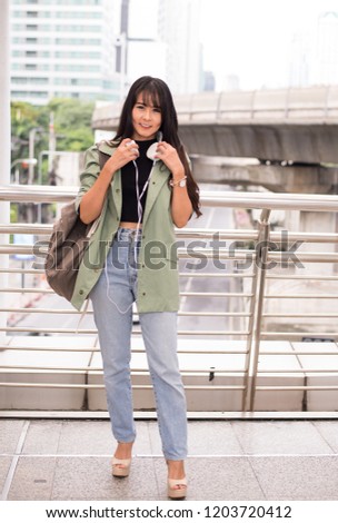 Beautiful young teen using headphones and listening to music at shopping center