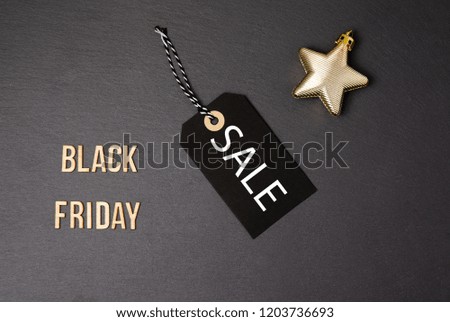 Black background and price label.  Black Friday. Sales concept. Copy space.  Black paper label against a dark grey background. Black Friday shopping sale concept with ticket Sale tag close up