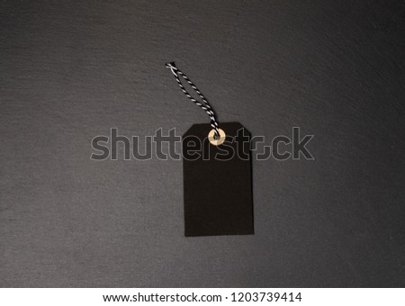 Black background and price label. Black Friday. Sales concept. Copy space. Black paper label against a dark grey background. Black Friday shopping sale concept with ticket Sale tag close up.