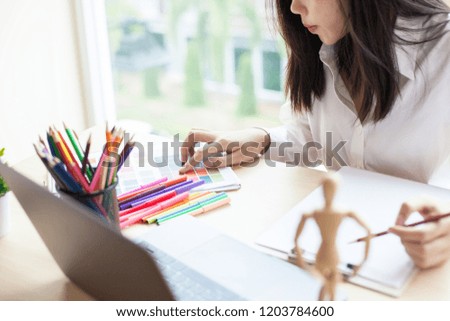 Asia Graphic designer working on computer tablet and Coloring device in studio office.