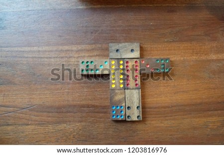Close up - Wooden Domino pieces  for Dominoes Game in wooden box and brown wood plank table - cartoon human patterns                 