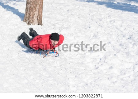 young man with sled in the snow. Young man making of the sled