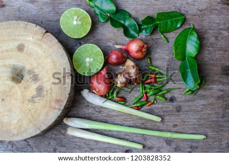 Kaffir lime leaves, lemongrass, galangal, peppers, onions, red, lime,. Herbs and spices spicy for Thai cooking on the wooden floor. Top view.