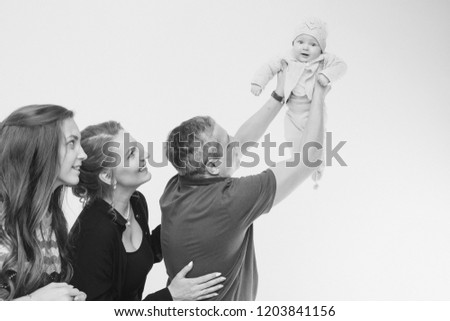 Family portrait on white background: newborn baby surrounded by man, woman and girl