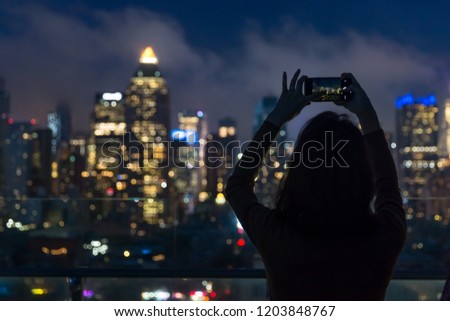 NEW YORK, USA - OCTOBER 11, 2018: Unrecognizable person taking photo of New York skyline at night