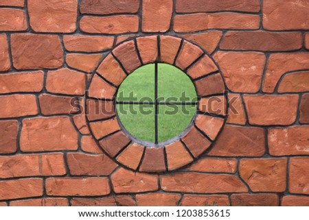 Old vintage red brick wall with a circular hole in the middle.