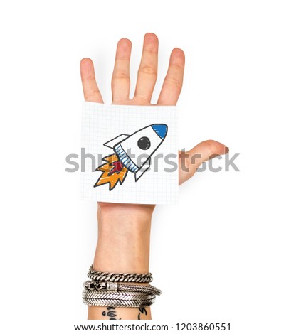 Hand showing a sticky note with a rocket launch