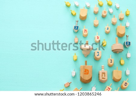 Image of jewish holiday Hanukkah with wooden dreidels colection (spinning top) over mint background