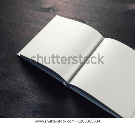 Blank opened book on wooden background. Template for graphic designers portfolios.