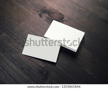 Blank white business cards on dark wooden background. Mockup for branding identity. Template for graphic designers portfolios.