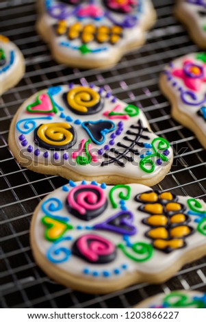 Sugar cookies in shape of sugar skull decorated with colorful royal icing for Día de Muertos-Day of the Dead holiday.
