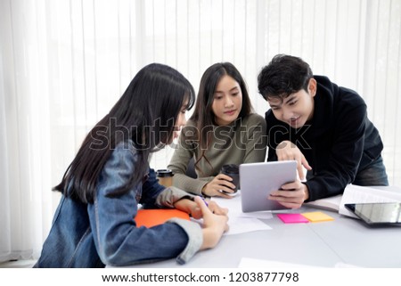 Group Students Smile and have fun and using tablet It also helps to share ideas in the work and project. And also review the book before the exam