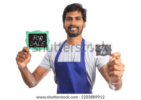 Friendly indian store manager selling company at discount as holding for sale and percent signs in both hands isolated on white
