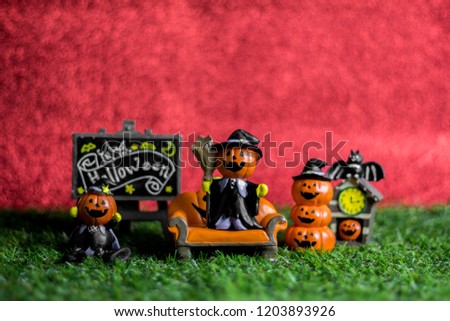 Halloween toys on the grass and the background is red.