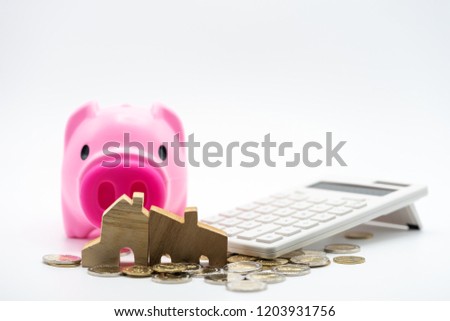 House model, piggy bank, and calculator on coins stacks. Concept for money saving for housing, property ladder, mortgage and real estate investment .