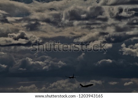 2 planes crossing in a cloudy and bright sky