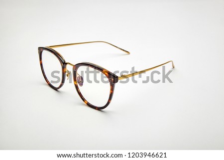 a pair of leopard-print gold glasses on white