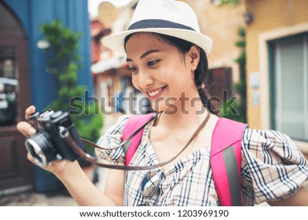 Close up of young hipster woman backpack traveling taking photo in urban.