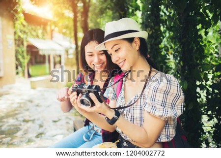 Two of woman having good time while sitting at branch after walking through the urban.