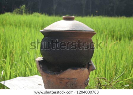 this pic show the earthen pot cooking for steam rice at rice field countryside Thailand.
