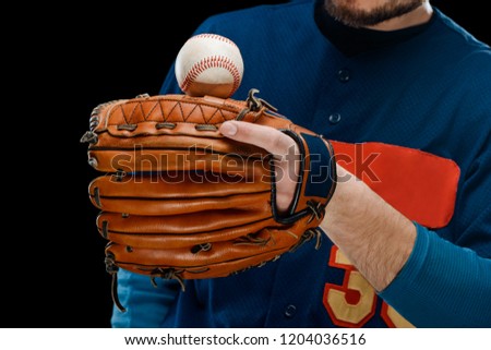 Ball balancing on pitcher's leather mitt put on player's hand. Baseball equipment and gear, close view.